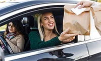 Driver receiving food in brown bag