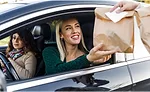 Driver receiving food in brown bag