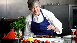 Chef sprinkling herbs on dish