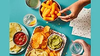Hands reaching for salty snacks
