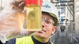 Cargill worker holding vial of oil