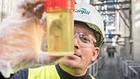 Cargill worker holding vial of oil
