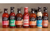 Assortment of zero-sugar condiments and sauces, including sweet chili sauce, barbecue sauce, ketchup, ranch dressing, and teriyaki marinade, displayed on a countertop.