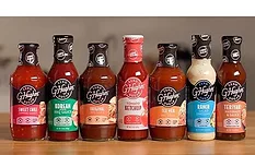 Assortment of zero-sugar condiments and sauces, including sweet chili sauce, barbecue sauce, ketchup, ranch dressing, and teriyaki marinade, displayed on a countertop.