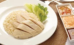 Plate of Hainanese Chicken Rice Next to Dipping Sauces
