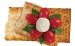 Crackers With Seeds Topped with Cherry Tomatoes and Mozzarella Cheese