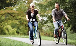 A Woman And Man Riding Bicycles Next to Each Other