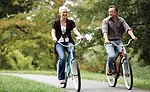 A Woman And Man Riding Bicycles Next to Each Other