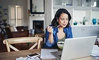 Woman Eating While Working From Home