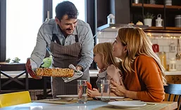 Man Serving Prepared Meal to Wife and Daughter at Home