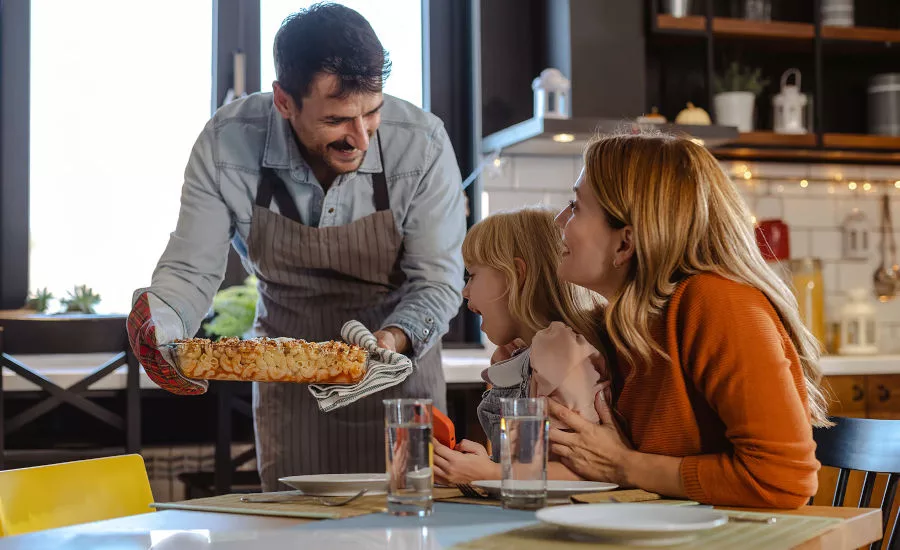 Man Serving Prepared Meal to Wife and Daughter at Home