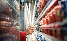 Hand reaching into dairy cooler