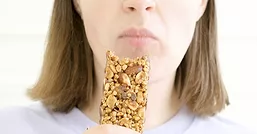 women eating protein granola bar