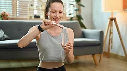 woman pouring supplement into water
