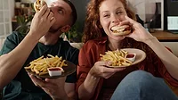 Couple eating burgers and fries