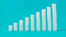 A column chart made of sugar cubes with a blue background.