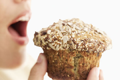person biting into muffin