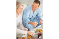 man and woman eating muffins