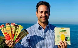 Simon Sacal, CEO of Solely Inc, Holding Two of Solely's Snack Products