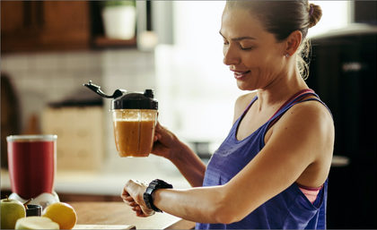 Woman Looking at Watch and Holding Smoothie